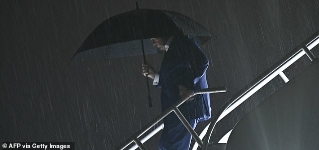 US President Donald Trump disembarks Air Force One while holding an umbrella in the rain at Palm Beach International Airport in West Palm Beach, Florida on October 16, 2026 (Photo by Brendan SMIALOWSKI / AFP via Getty Images)